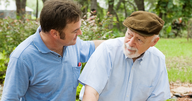 Adult son out for a walk with his father, who has alzheimers disease.