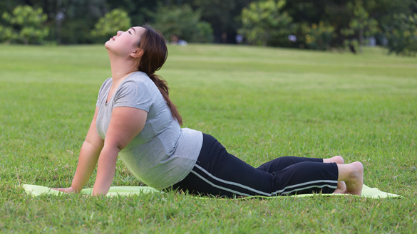 34145658 - obese women yoga on grass