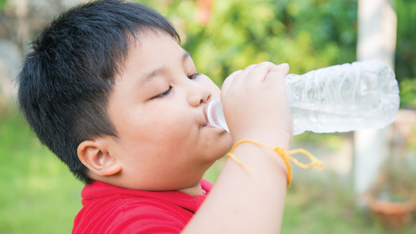 38680130 - asian fat boy drinking water.