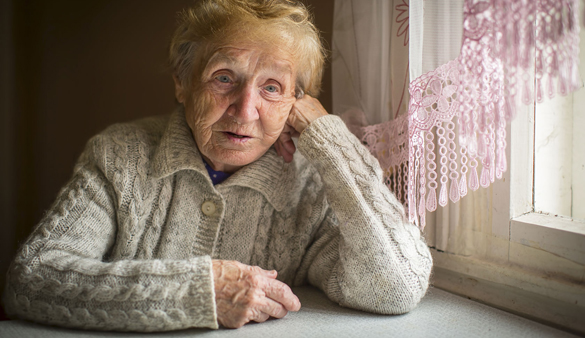 49489275 - an elderly woman sits alone near the window.