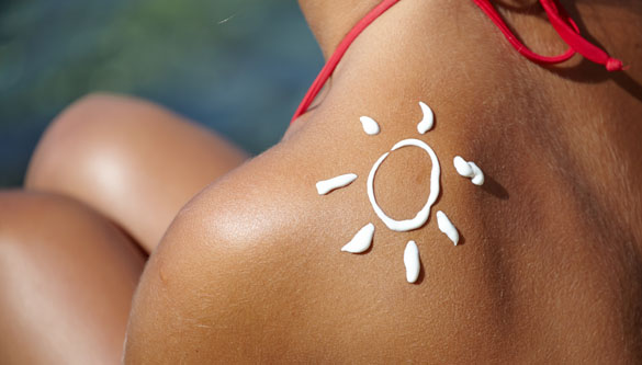 Woman With Suntan Lotion At The Beach In Form Of The Sun